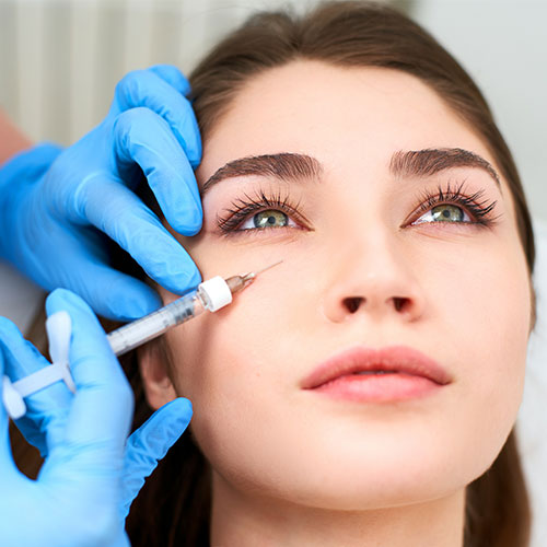 brunette woman having the treatment of under eye filler
