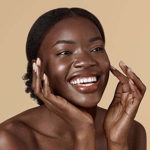 beautiful black model feeling her skin after a microdermabrasion treatment
