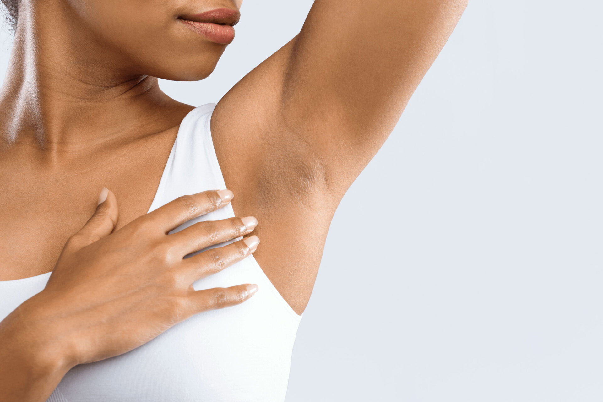 Beautiful woman feeling armpit after having excessive sweating treatment