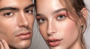 closeup of a beautiful woman and man against a grey background