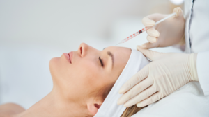 aesthetic professional performing a facial aesthetic injection on a relaxed female patient