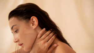 Woman with wet dark hair touching her neck gently